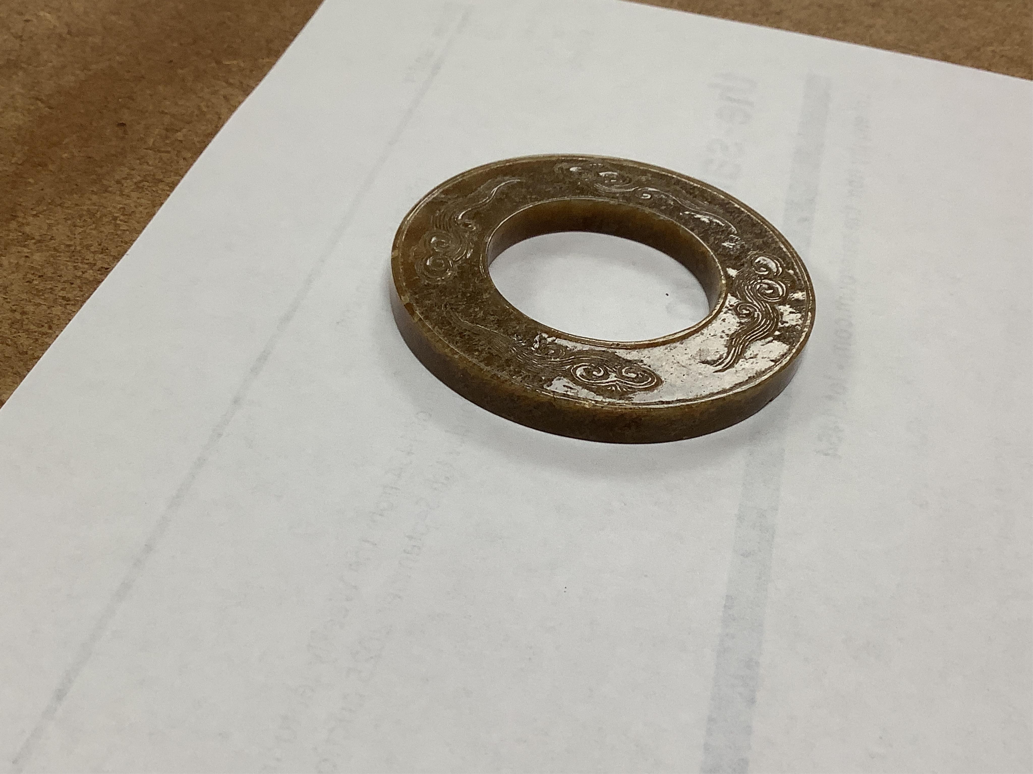 A Chinese russet jade dragon disc, 5.5cm diameter